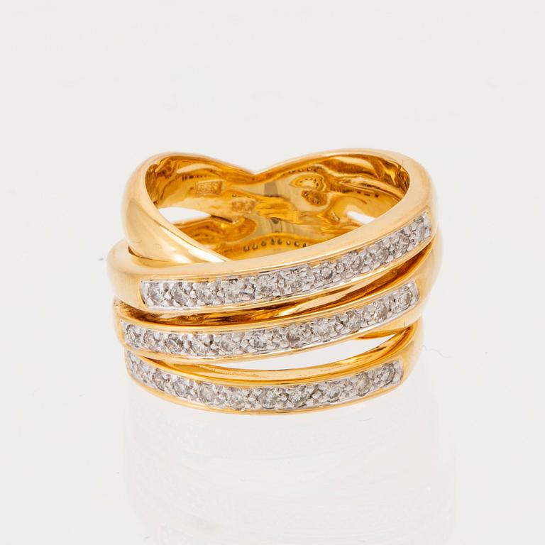 An 18K gold ring set with round brilliant-cut diamonds.