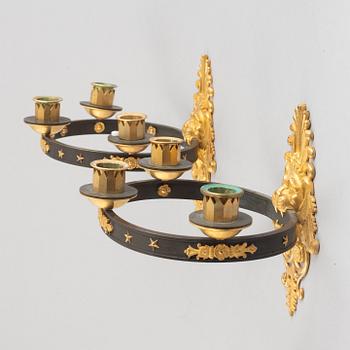 A pair of French Empire-style ormolu and patined bronze three-branch appliques, late 19th century.