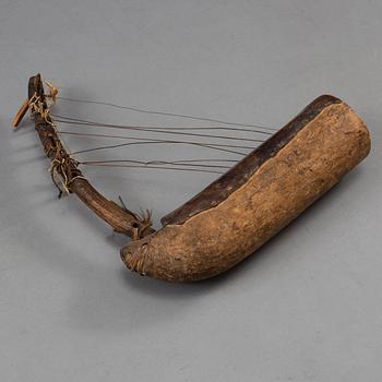 A STRING INSTRUMENT, wood, leather and rope, Africa first half of the 20th century, length 39,5 cm.