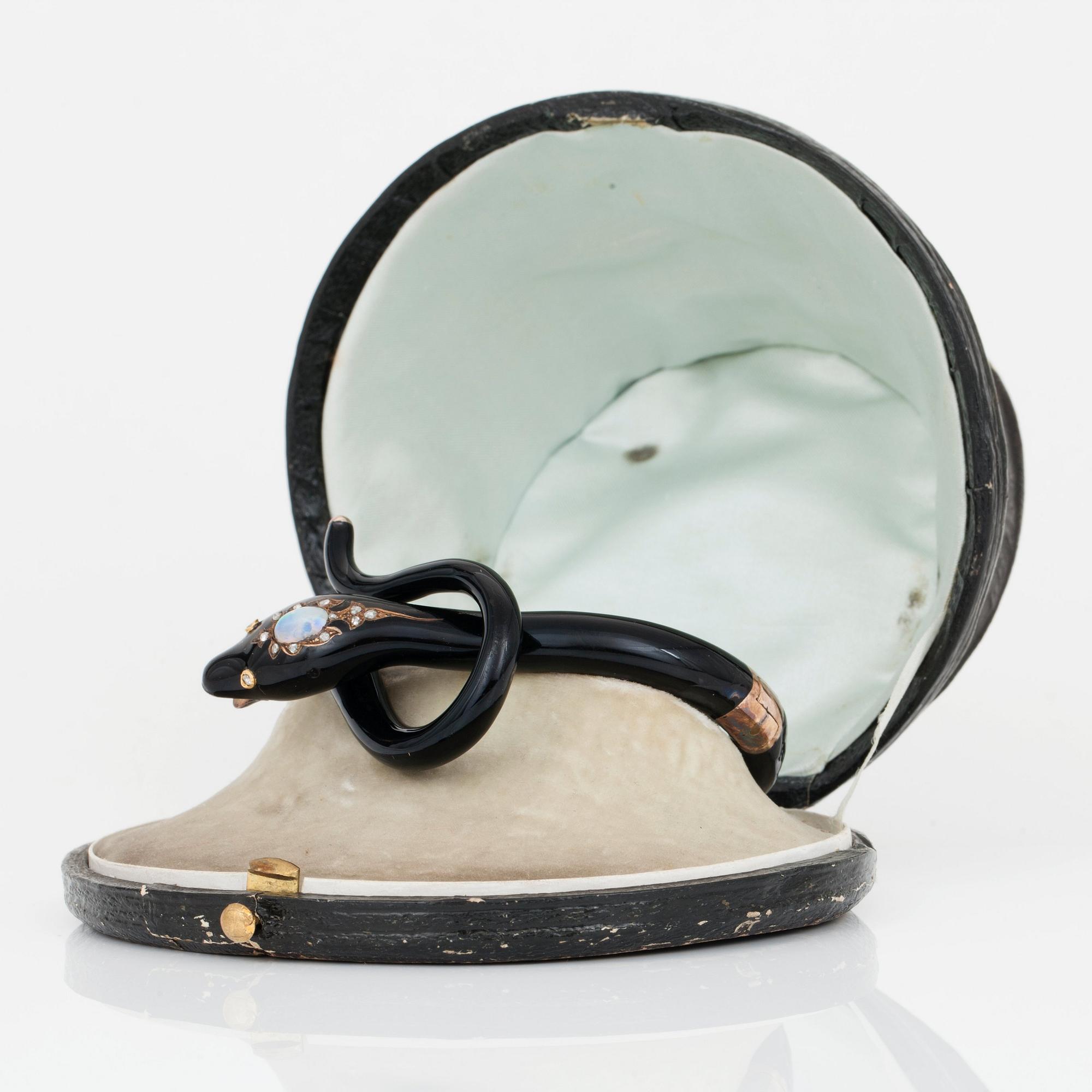 A Victorian snake bracelet in black enamel set with an opal and rose-cut diamonds.