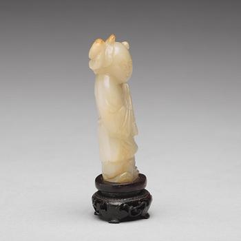 A carved nephrite figure of a boy with a lotus branch, Qing dynasty (1644-1912).