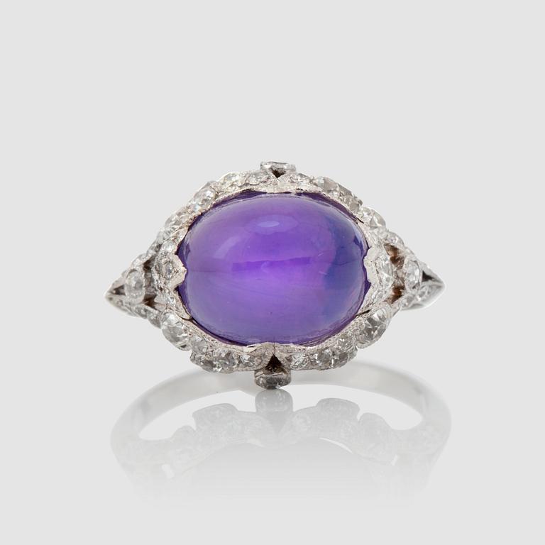 An untreated natural violet star sapphire, 9.66 cts, and diamond ring, signed Cartier.