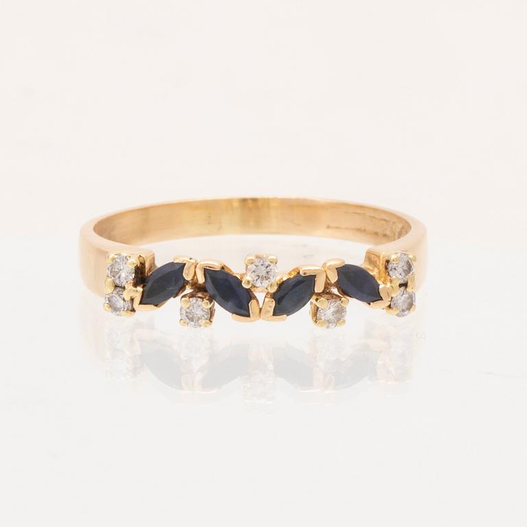 An 18K gold ring set with marquise cut, likely,  sapphires and round brilliant cut diamonds.