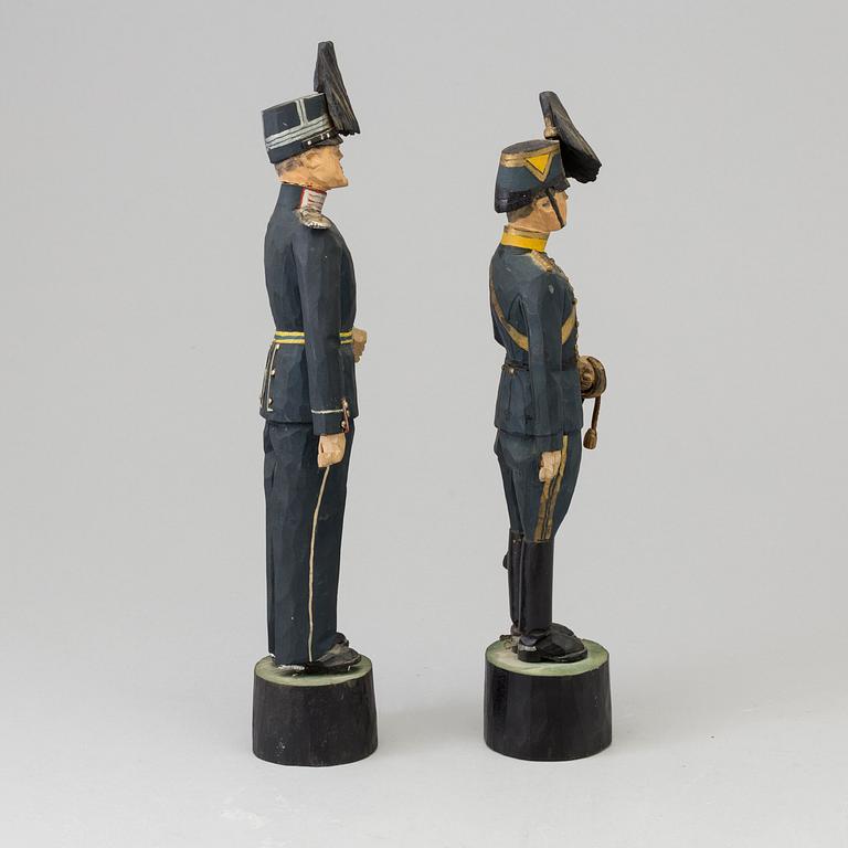 Two wooden sculptures depicting Swedish officers, signed and daterd 1939.