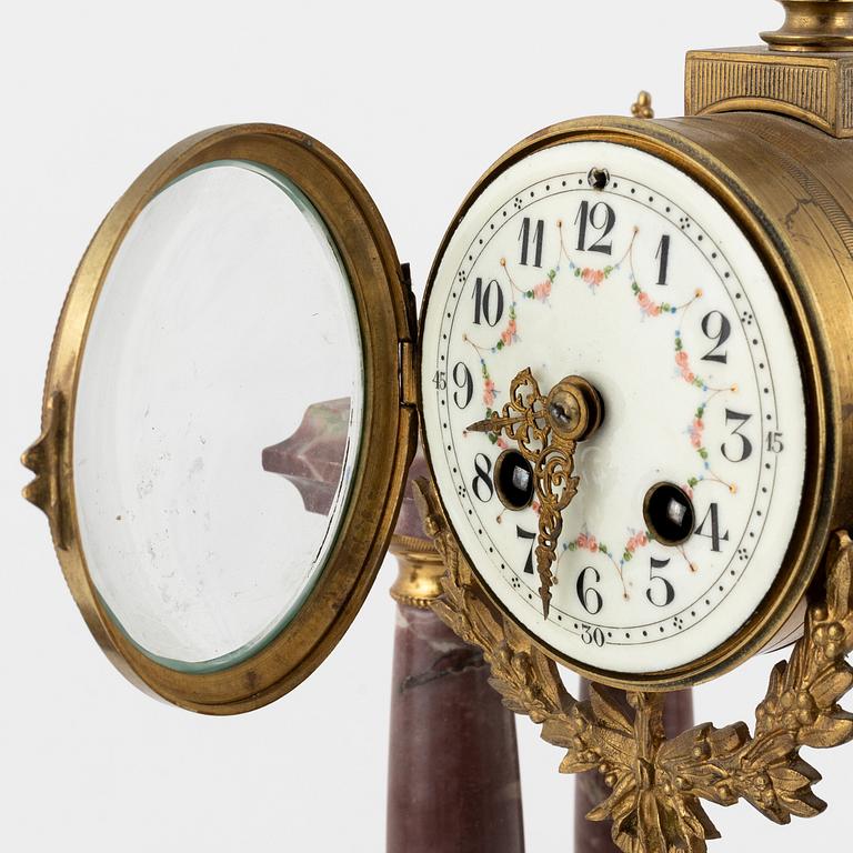 A Louis XVI-style Mantle Clock and a pair of decorative urns, early 20th Century.