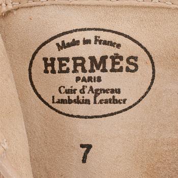 HERMÈS, a pair of beige lambskin leather gloves.