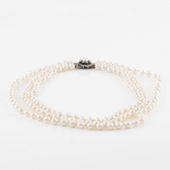 Necklace, three strands of cultured pearls, clasp in silver set with brilliant-cut diamonds.