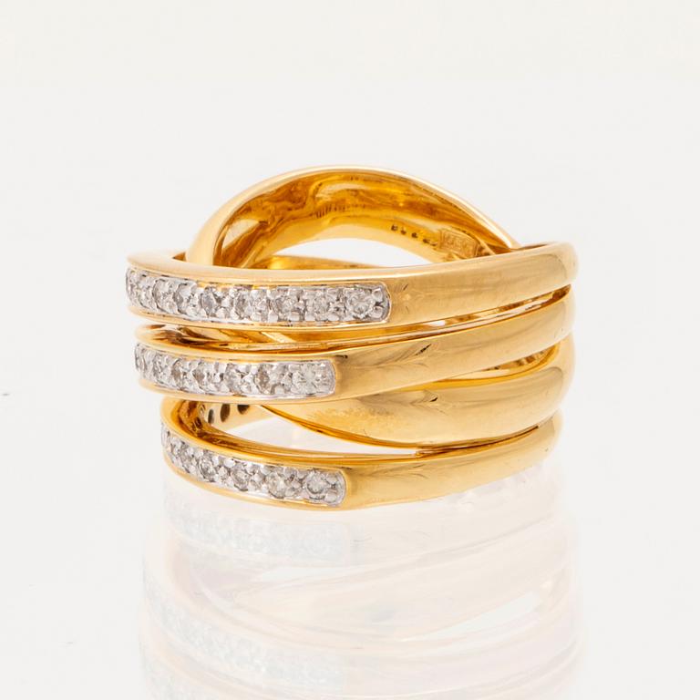 An 18K gold ring set with round brilliant-cut diamonds.