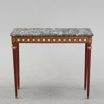 A Louis XVI style console table with a marble top.