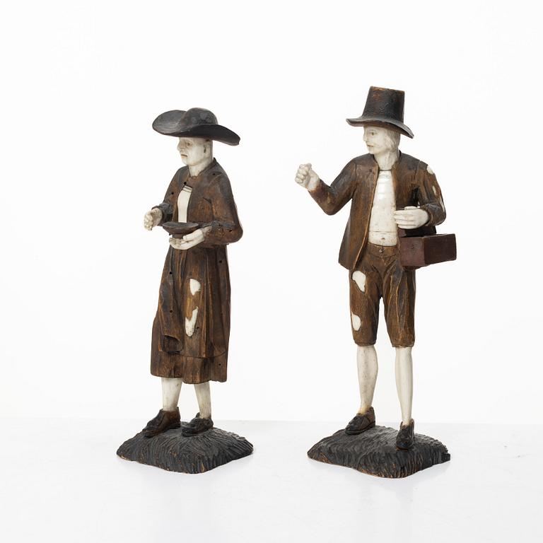 A pair of German carved bone and limewood figures by a follower of Simon Troger, early 18th century.