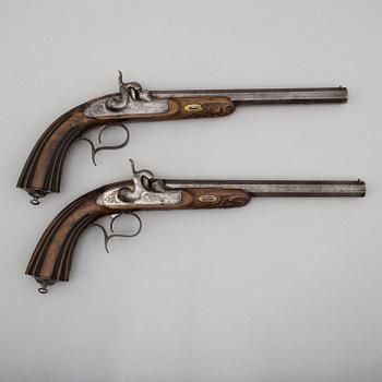 A pair of mid 19th century percussion pistols in a case marked Campagnac a Bordeaux.