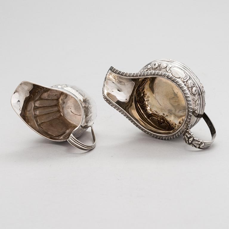 Two sterling silver milk jugs, London 1794 och 1828.