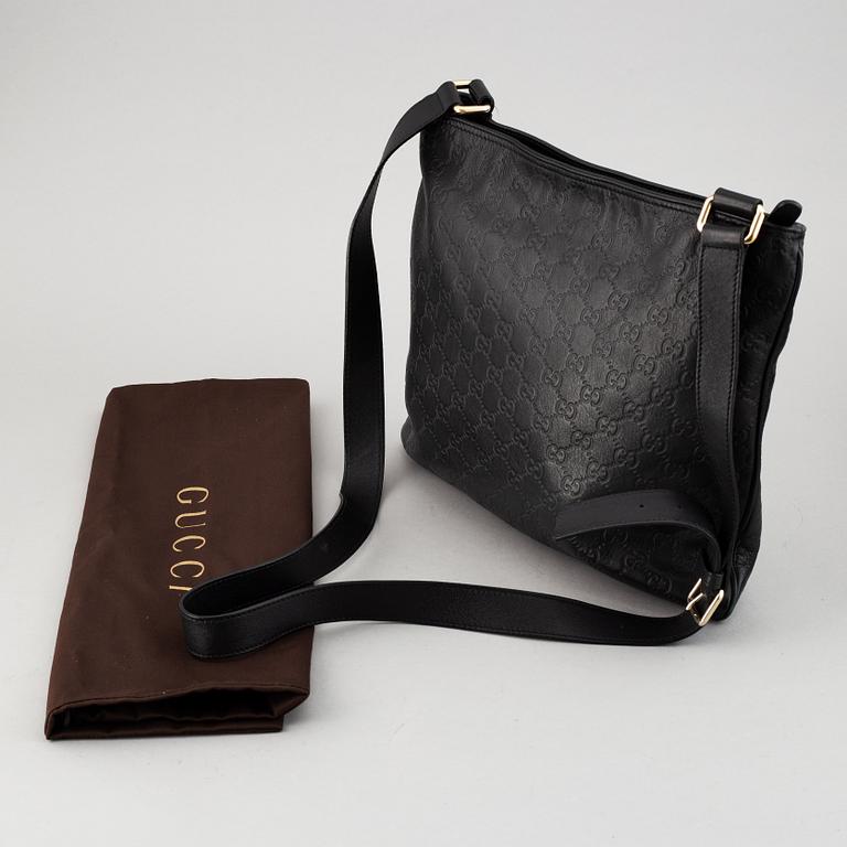 Gucci, a leather messenger bag.