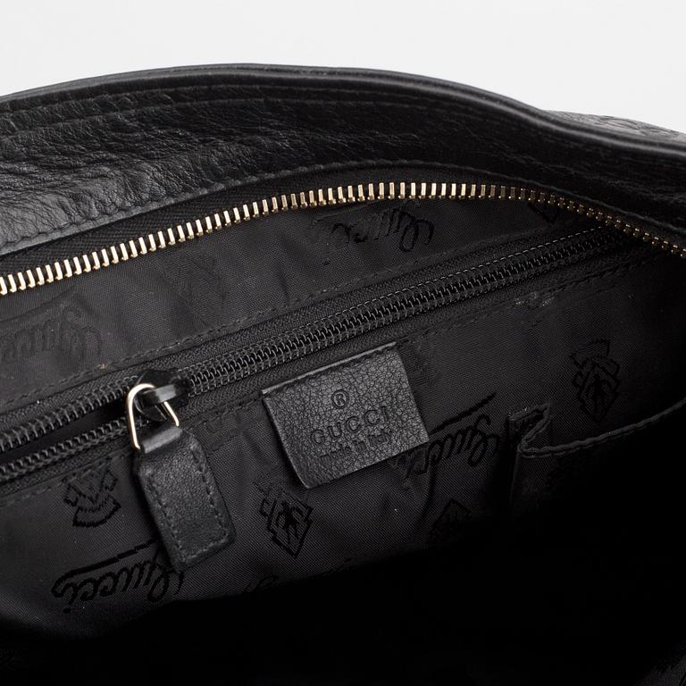 Gucci, a leather messenger bag.