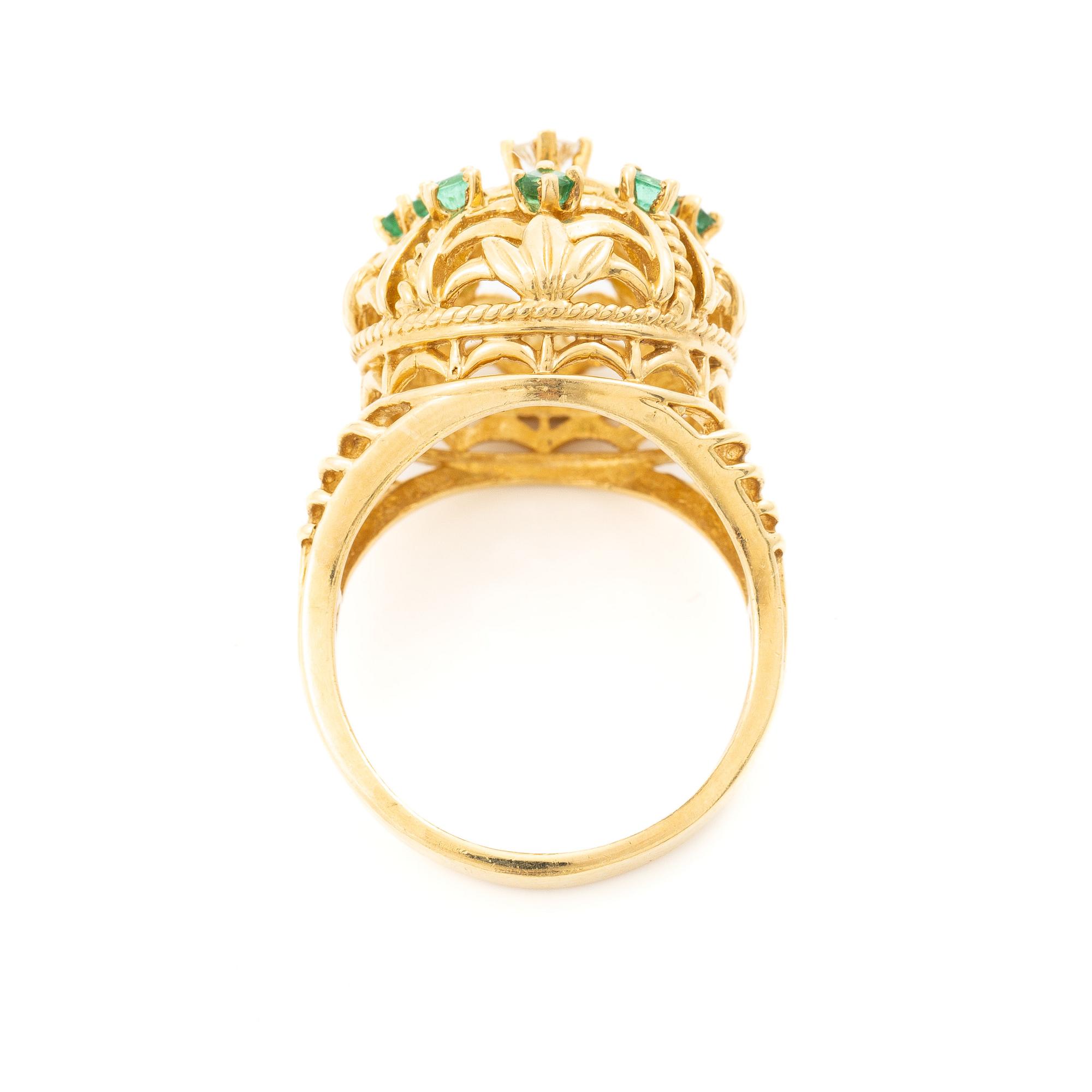 18K gold ring with small emeralds and a round brilliant-cut diamond.