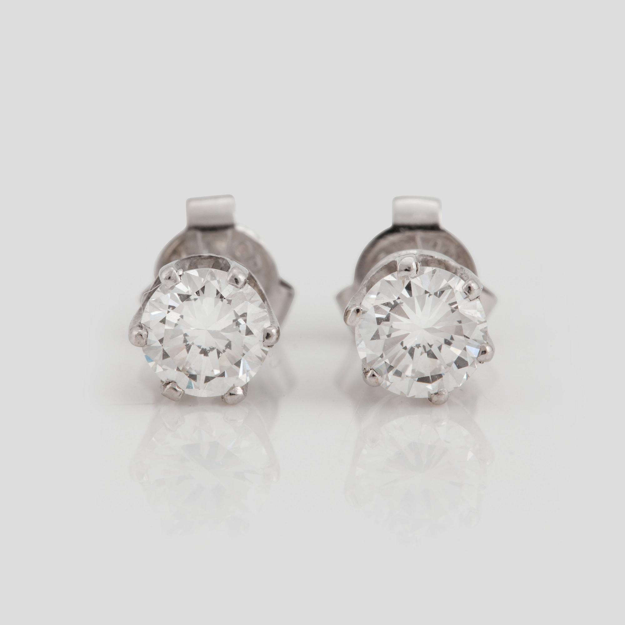 A pair of brilliant cut diamond earrings.