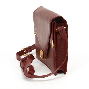 A wine red leather shoulder bag and wallet by Cartier.