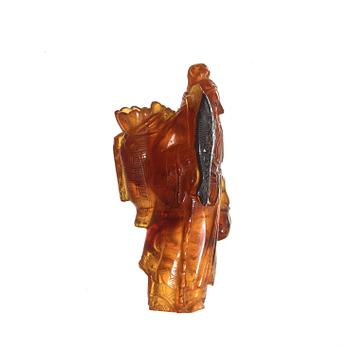 An amber figurine of a standing fisherman with prey, Qing dynasty (1644-1912).