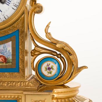 A mid-19th-century French gilt-brass mantel clock with a pair of candelabra by Dussault.