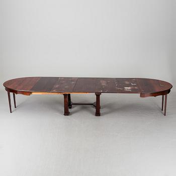 A late 19th century dining table with ten chairs and five extension leaves.