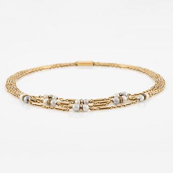 A W.A. Bolin necklace in 18K gold with pearls and white discs.