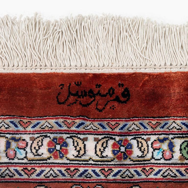 A signed pictoral silk Qum rug, c. 203 x 127 cm.