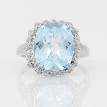 RING, 18K vitguld med chequerslipad blå topas, ca 5,23 ct, diamanter tot ca 0,20 ct. Vikt ca 4,17 g.