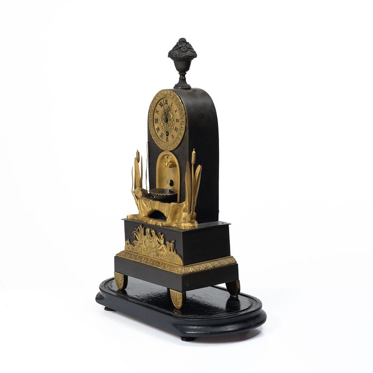 A French Charles X ormolu and patinated bronze mantel clock, ca 1820's.