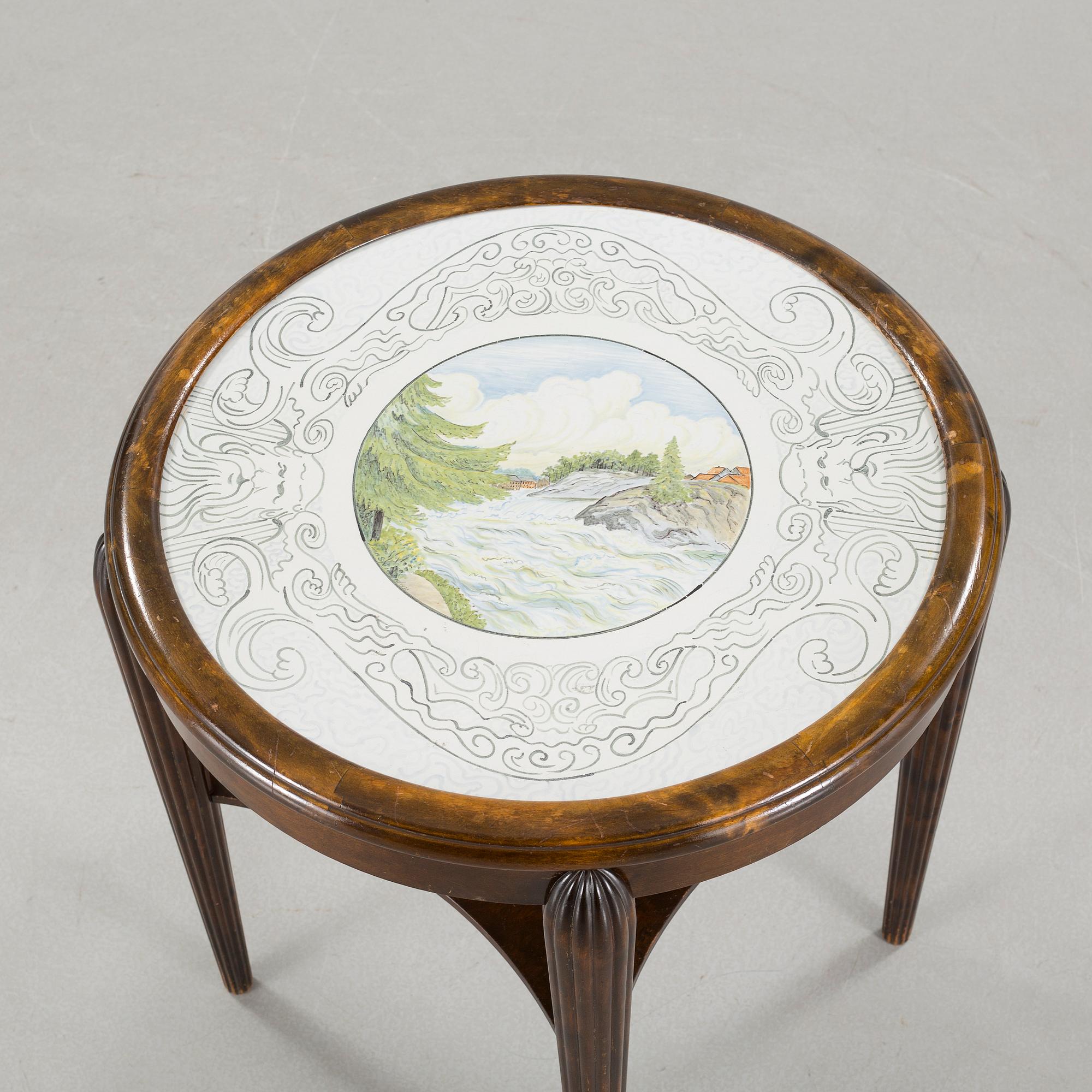 A table from the first halft of the 20th century with a "Kalmar Fajans" tabletop, painted by John Sjöstrand.