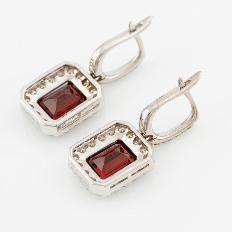 A pair of earrings in 18K white gold with faceted garnets and round brilliant-cut diamonds.