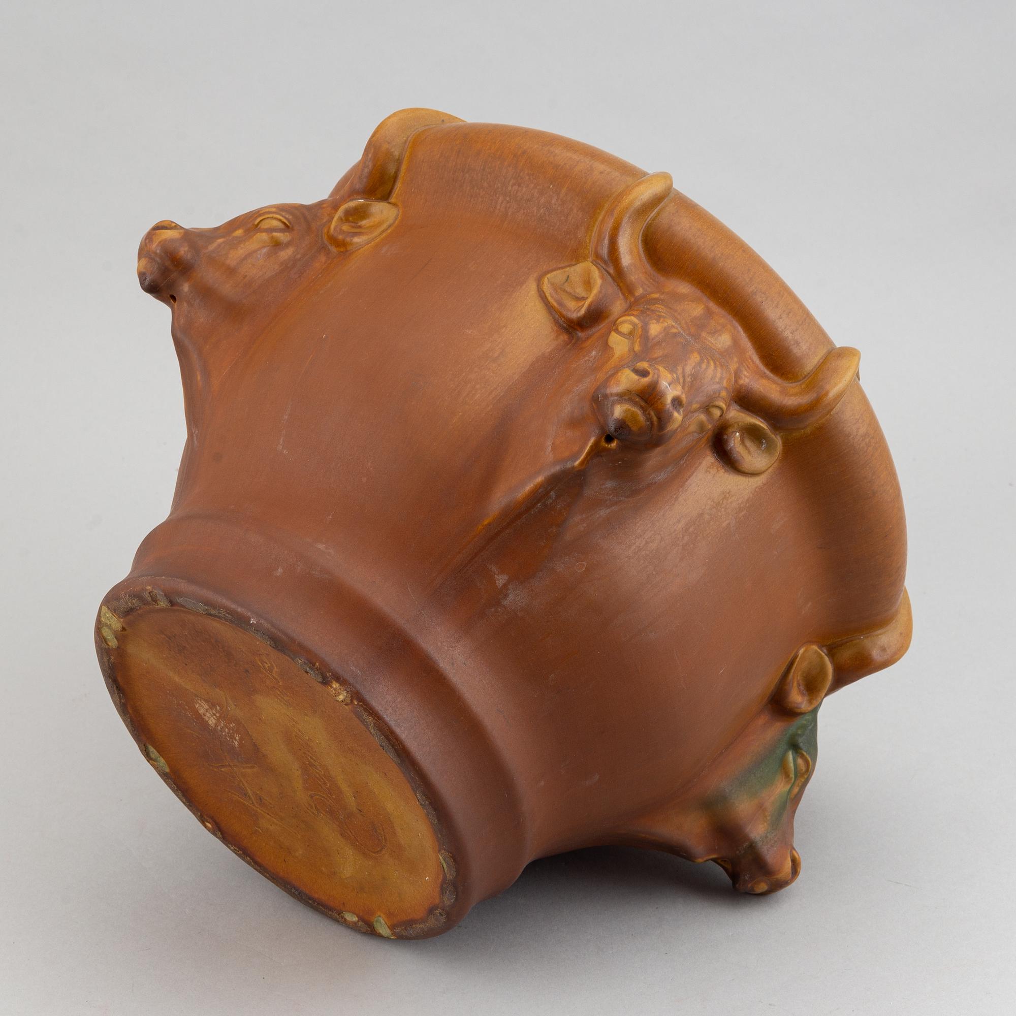An earthenware pot decorated with four bulls heads. Probably by Karl Hansen Reistrup for Herman Kähler. Around 1900.