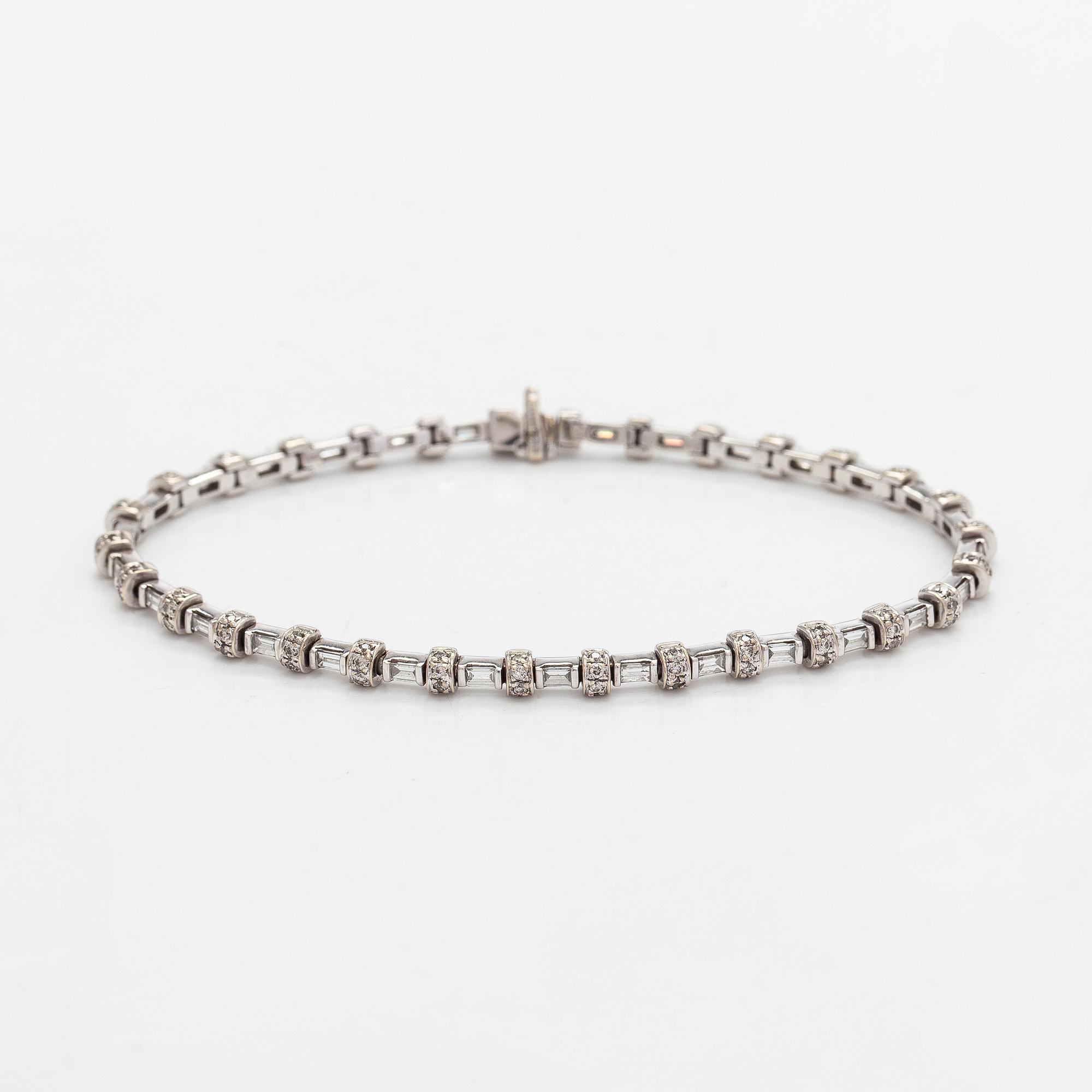 An 18K white gold bracelet set with baguette and brilliant-cut diamonds.