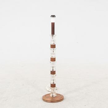 A 1970s wood and glass floor lamp.
