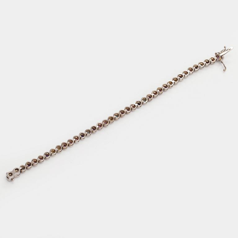 Rannekoru, 18K valkokultaa ja monivärisiä kiviä.