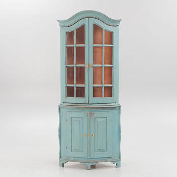A corner display cabinet, 19th century with a later base.