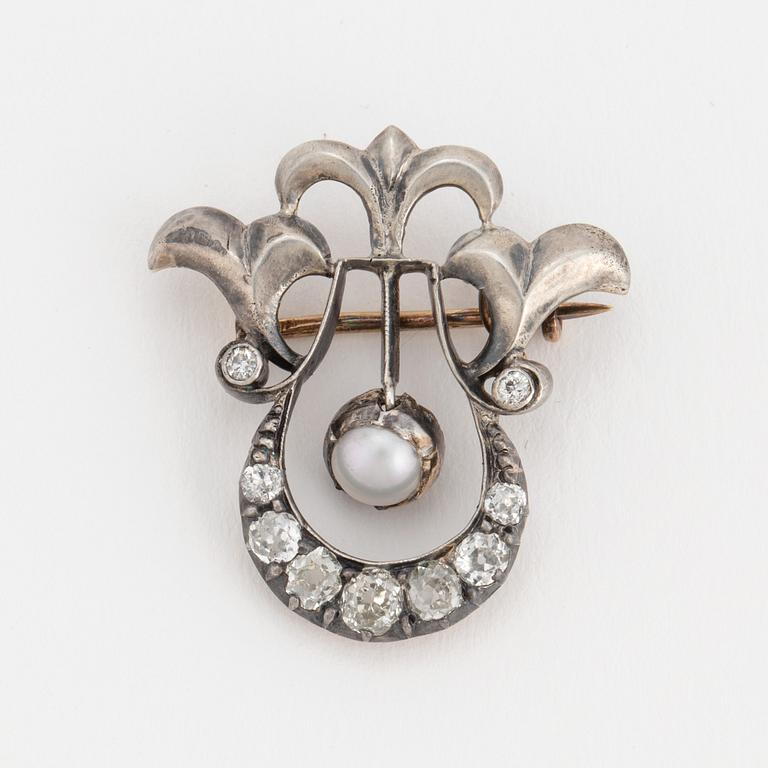A brooch set with a mabé pearl and old-cut diamonds.