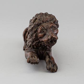 A 17TH CENTURY CARVED WOOD FIGURE OF A LION.