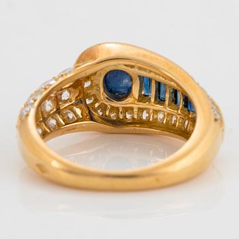 An 18K gold Wempe ring set with sapphires and round brilliant-cut diamonds.