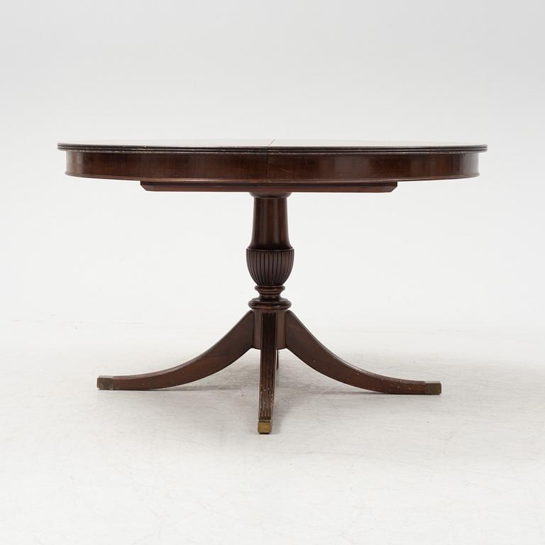 A round mahogany dining table with three additional leaves.
