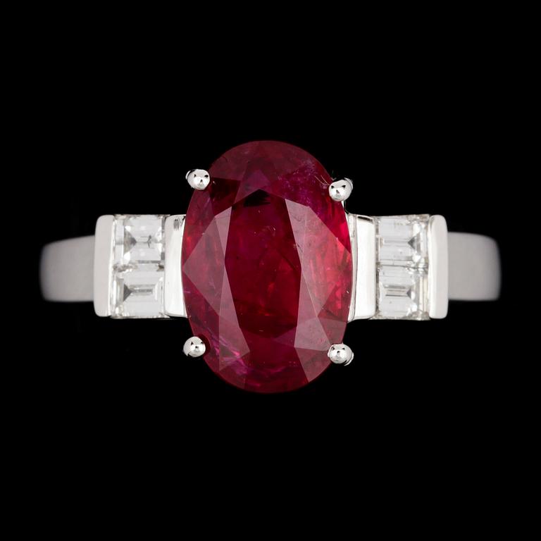 An oval ruby, 3.02 cts, and emerald cut diamond ring.