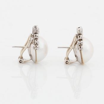 A pair of 18K white gold earrings set with mabe pearls and round brilliant-cut diamonds.