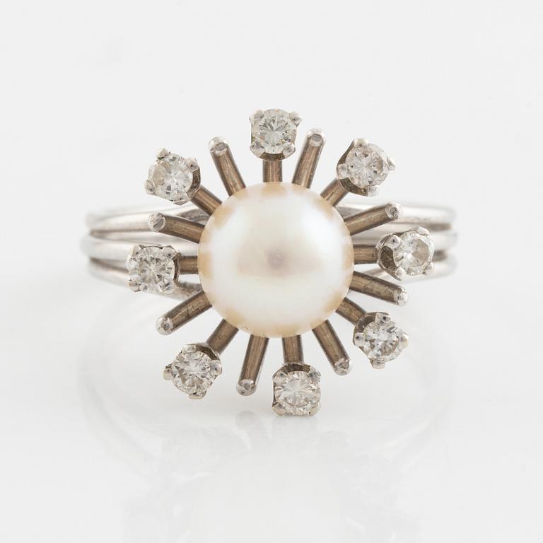 An 18K gold ring set with a cultured pearl and round brilliant-cut diamonds.