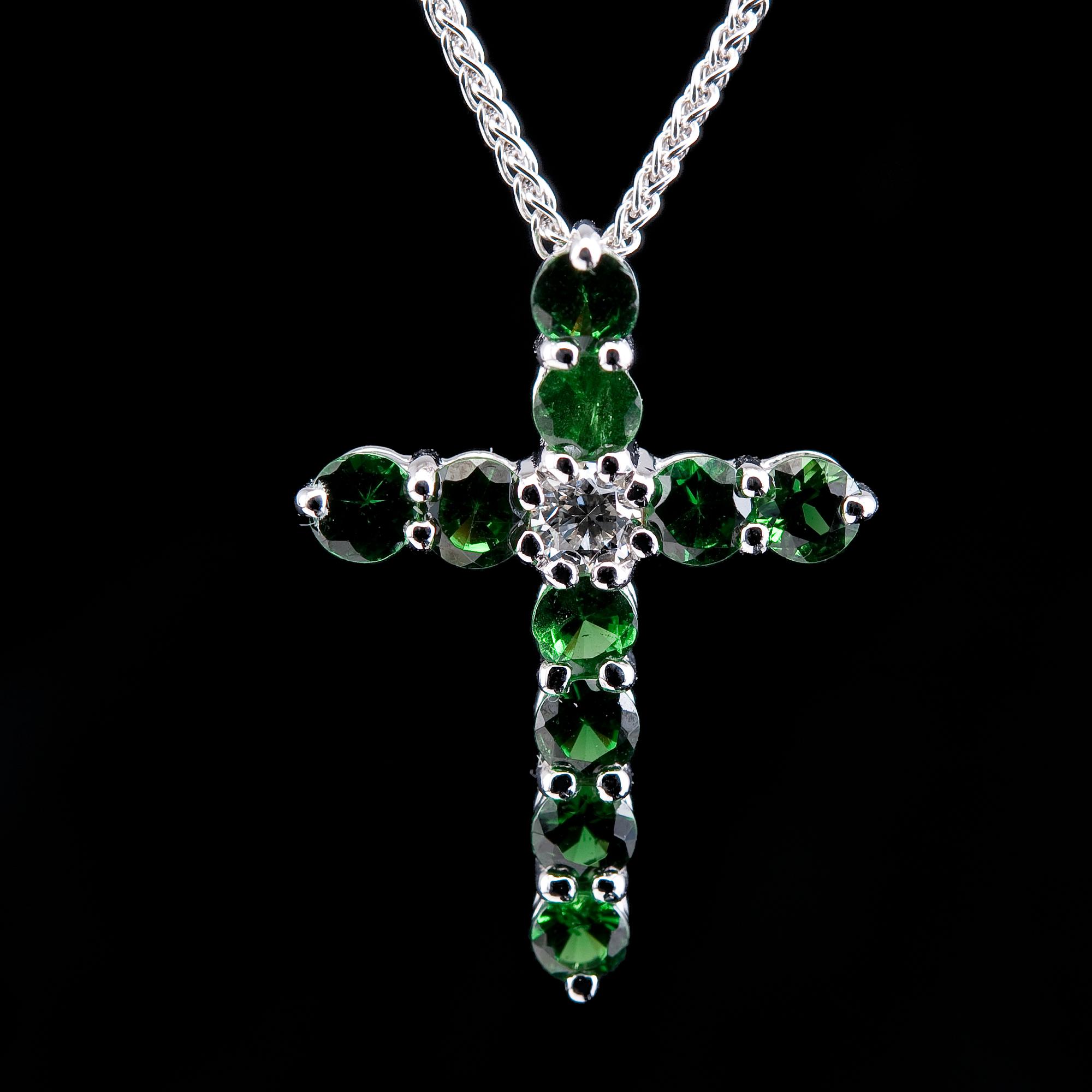 A CROSS PENDANT, 12 tsavorites 0.75 ct, 1 brilliant cut diamond 0,12 ct. VS.