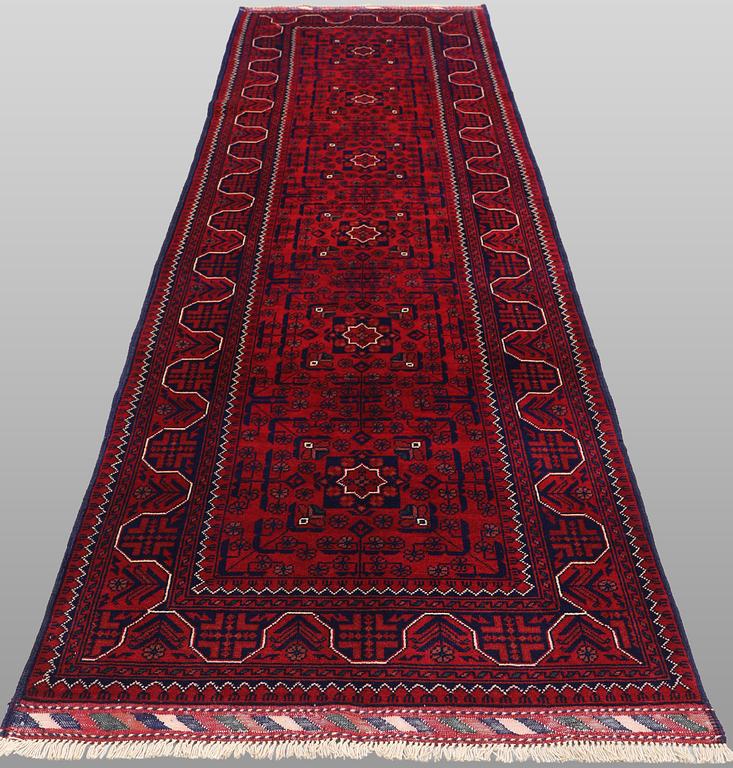 A Afghan runner carpet, 304 x 84 cm.
