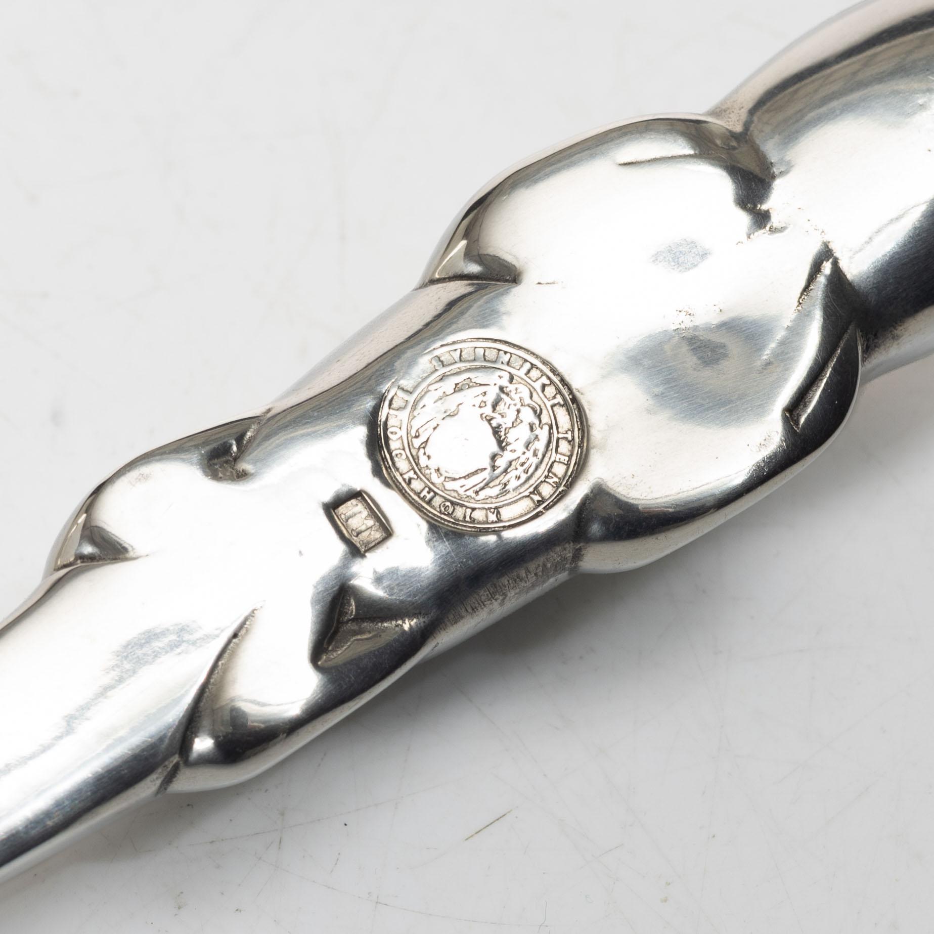 Firma Svenskt Tenn, Candelabrum, 'Vänskapsknuten', and paper knife, 'Alligator'.