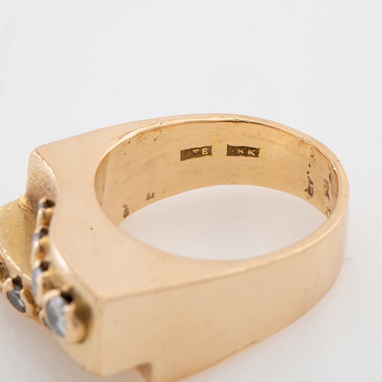 Ring in 18K gold set with round brilliant-cut diamonds and a round faceted gemstone.