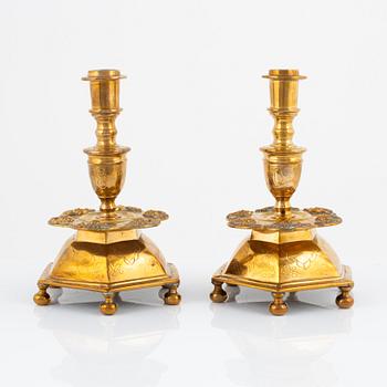 A pair of brass barock style candlesticks.