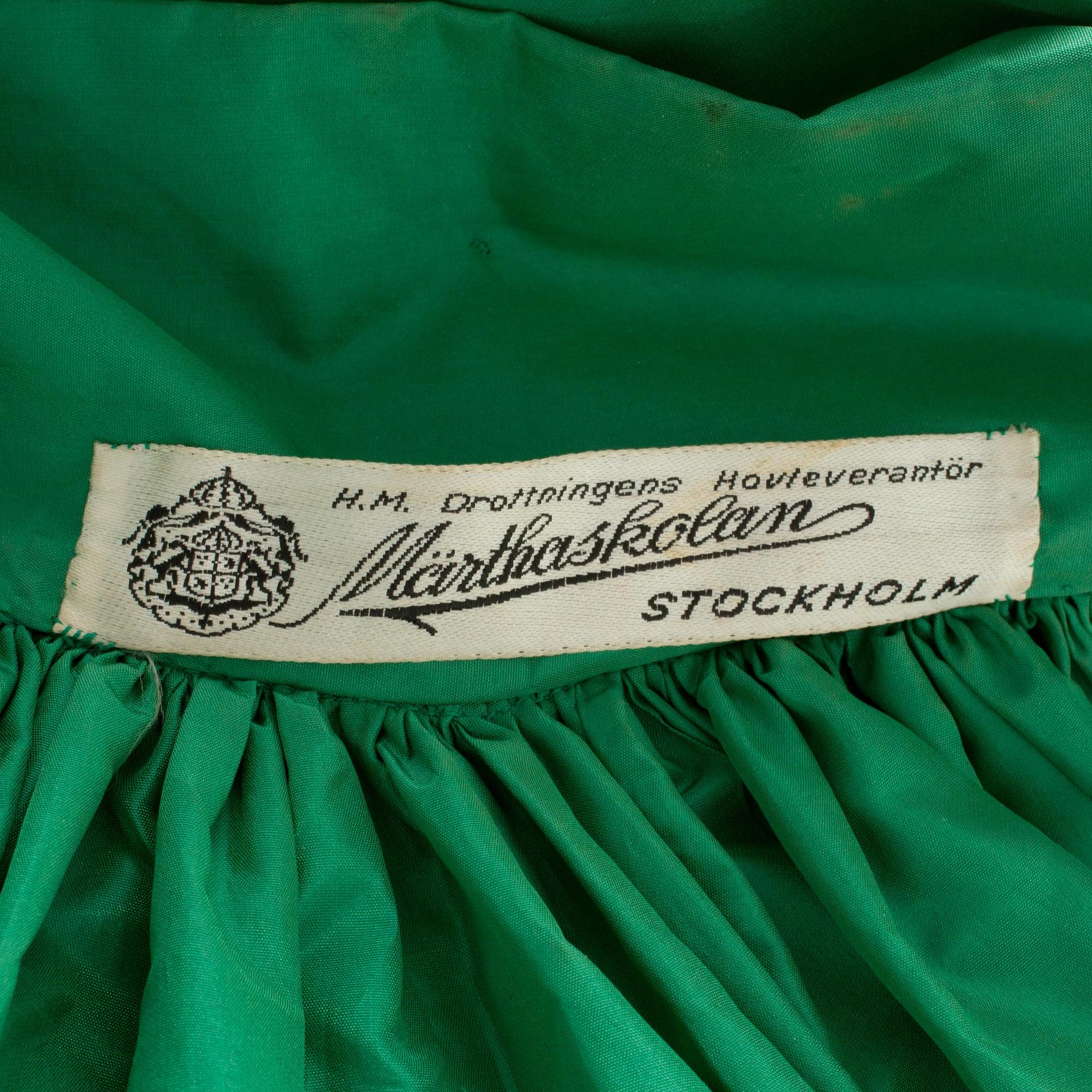 MÄRTHASKOLAN, a green silk evening coat.