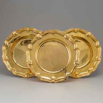 A German set of twelve 19th century silver-gilt plates, mark of Hossauer, Berlin. Rokoko-style.