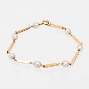 An 18K gold bracelet set with cultured pearls.